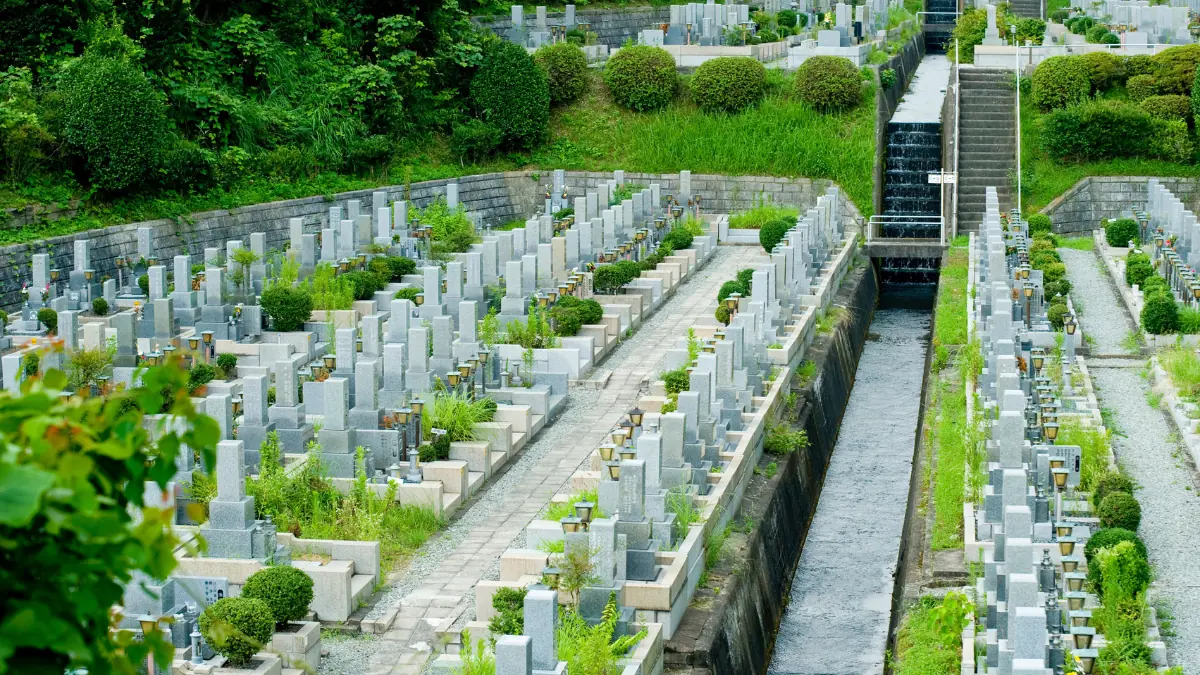 斜面に整然と墓石が並ぶ広い霊園を見下ろした風景、墓じまいと改葬を考える墓地の全景