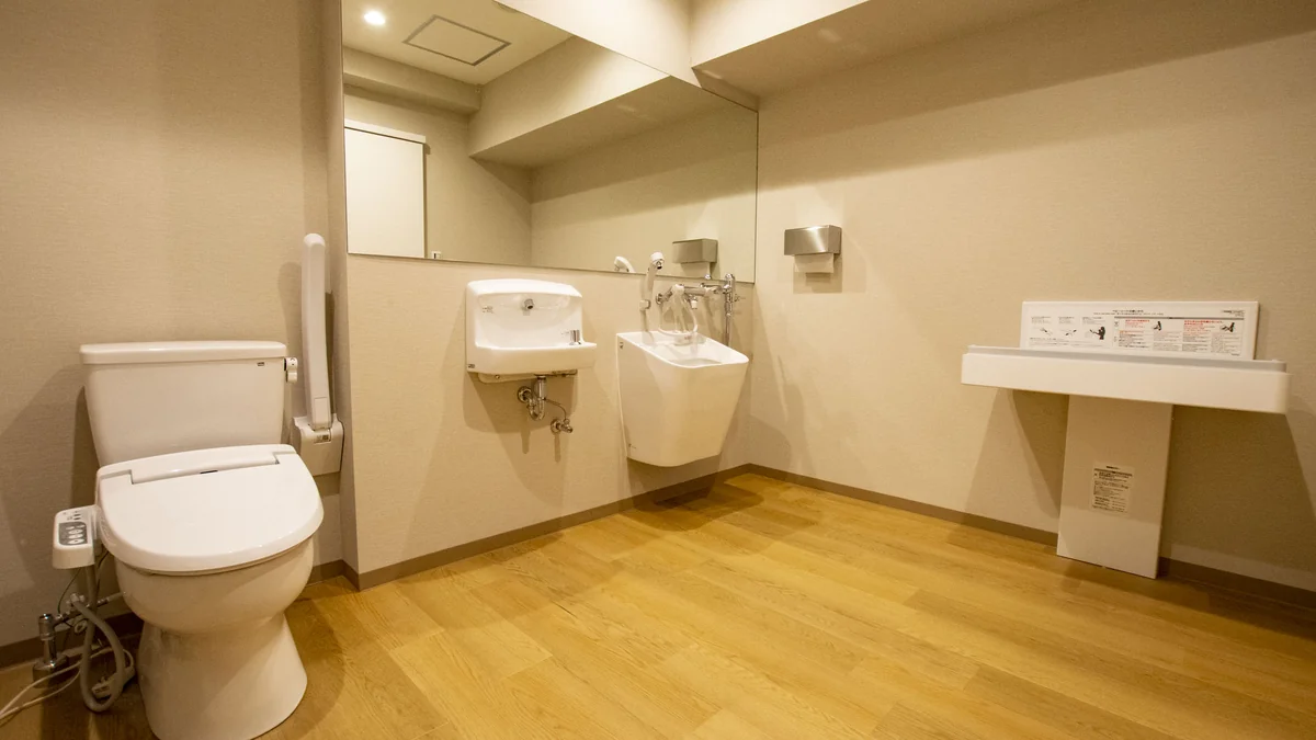 手すり付きトイレとオストメイト対応の流し、ベビーシートを備えた想送庵カノンのユニバーサルトイレ。車椅子の方も使いやすい広々とした設計