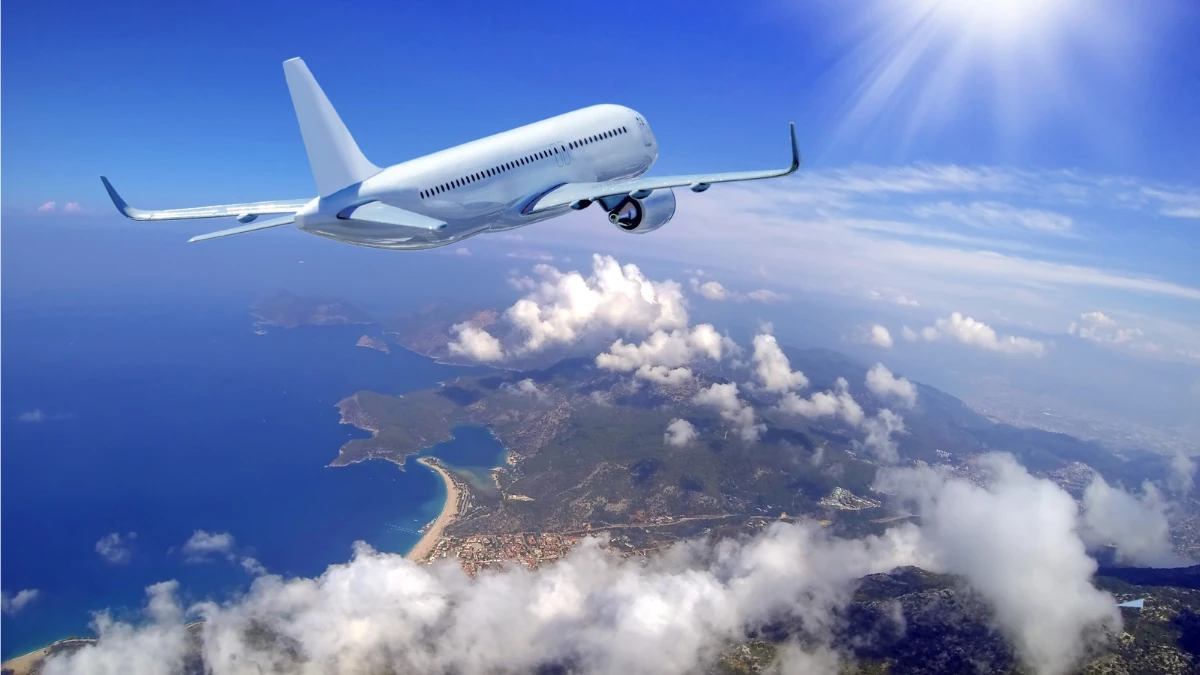 青空と雲海の上を飛ぶ旅客機、長期保全を可能にするエンバーミングで海外搬送や時間を得る選択肢をイメージした風景
