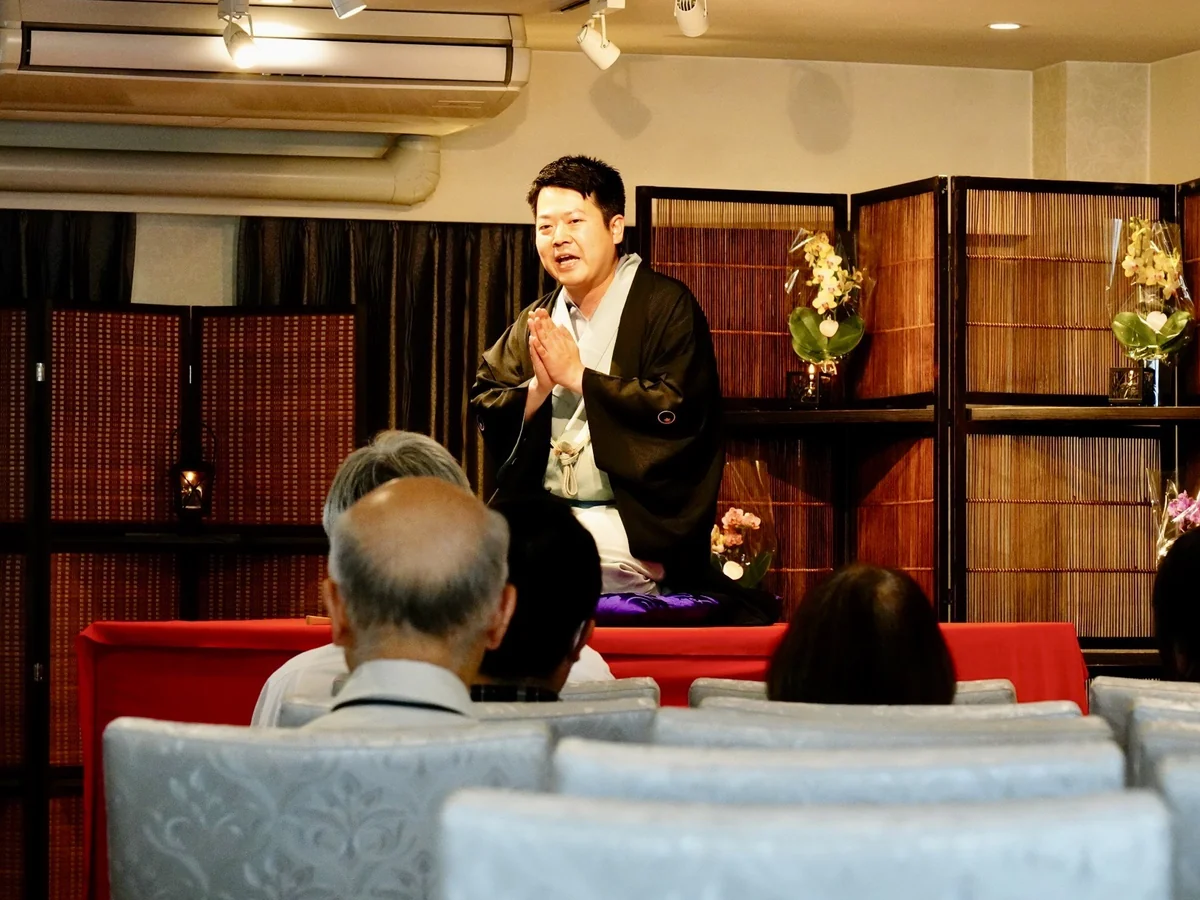 ご供養落語の高座で、手を合わせながら語りかける三遊亭仁馬さん